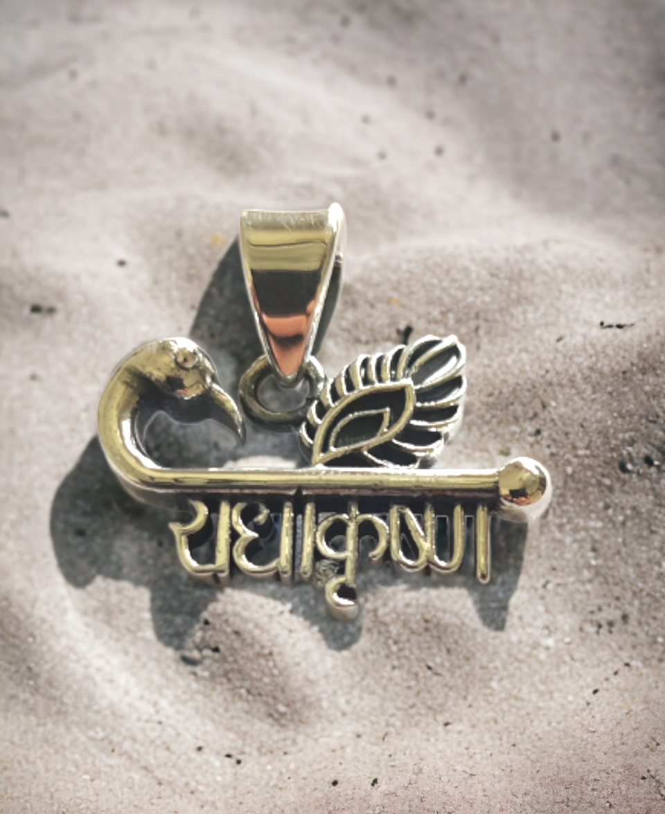 This Radha Krishna pendant showcases intricate craftsmanship with divine symbolism. The design beautifully combines a flute and peacock feather, both associated with Lord Krishna, alongside the sacred Hindi inscription “राधाकृष्ण” Made with 925 sterling silver and finished with a glossy silver plating, it ensures durability and a premium look. Perfect for those who appreciate spiritual jewelry with a modern touch, this piece reflects devotion, love, and elegance in every detail.