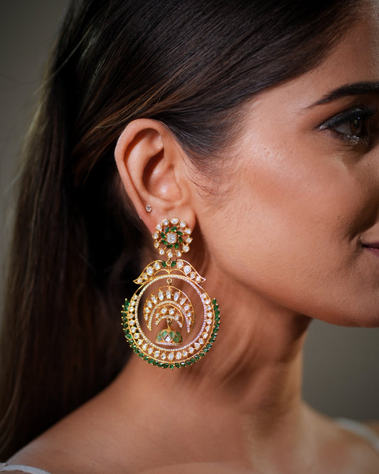 Moissanite Polki Earrings in 925 Sterling Silver with luxurious 22K gold plating, handcrafted bridal Chandbali earrings with green emerald stones, designer Indian wedding earrings inspired by royal Mughal and Rajasthani jewelry traditions. Premium handmade ethnic earrings featuring sparkling Moissanite Polki diamonds, statement bridal jewelry for lehenga, saree, Anarkali and festive outfits. Luxury bridal Chandbali earrings with antique finish, perfect for brides, bridesmaids, wedding guests, reception, 