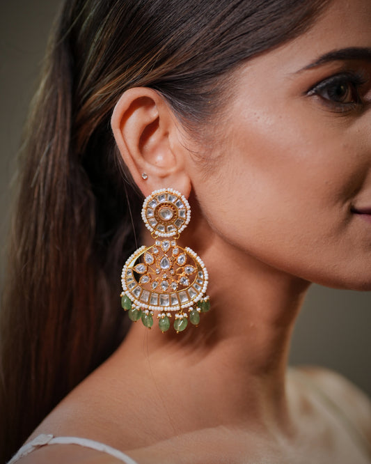 These handcrafted Polki Earrings Set with Green Emerald and Pearl in 925 Sterling Silver with luxurious 22K Gold Plating represent the timeless beauty of traditional Indian jewelry crafted with modern elegance. Inspired by royal Jaipur India jewelry artistry, these premium bridal earrings combine sparkling Polki stones, rich green emerald gemstones and delicate pearl