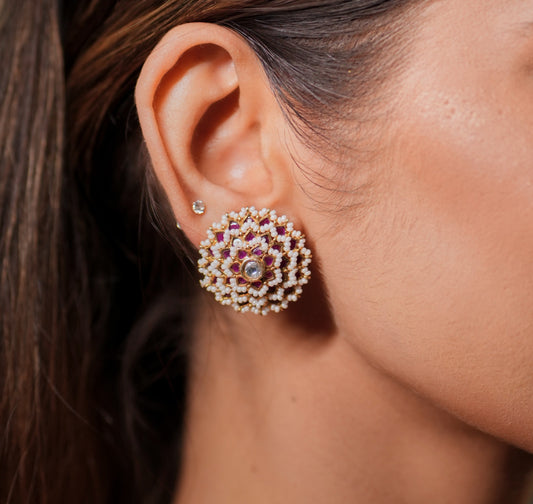 Experience the timeless elegance of this exquisite Polki Earrings Set with Pink Ruby and Pearl, beautifully handcrafted in 925 Sterling Silver and finished with a rich 22K Gold Plating. Inspired by the royal heritage of Rajasthan, these earrings combine traditional Indian artistry with modern sophistication, making them a perfect choice for weddings, festive celebrations, cultural events, and special occasions. The shimmering Polki stones, vibrant Pink Ruby accents and lustrous pearls create a luxurious des
