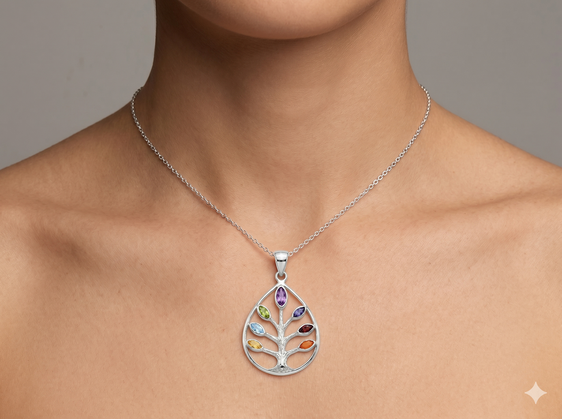 Embedded within the silver branches are seven authentic marquise-cut gemstones, each thoughtfully chosen to represent and align the body's major energy centers. From top to bottom, the pendant features Amethyst for spiritual awareness, Iolite for inner vision, Blue Topaz for clear communication, Peridot for heart-centered compassion, Citrine for radiant self-esteem, Carnelian for creative vitality, and Garnet for deep physical grounding. Together, these stones create a continuous flow of holistic energy 
